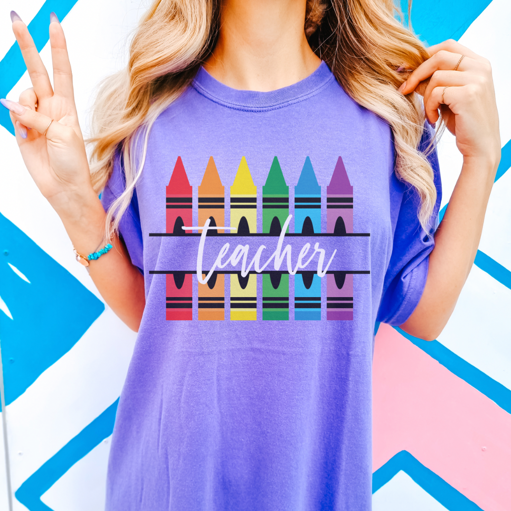 Crayon Teacher Graphic Tee, Comfort Colors crewneck t-shirt with a colorful crayon design, perfect teacher gift for back-to-school or everyday wear, made from soft cotton, available at Melody Faye.