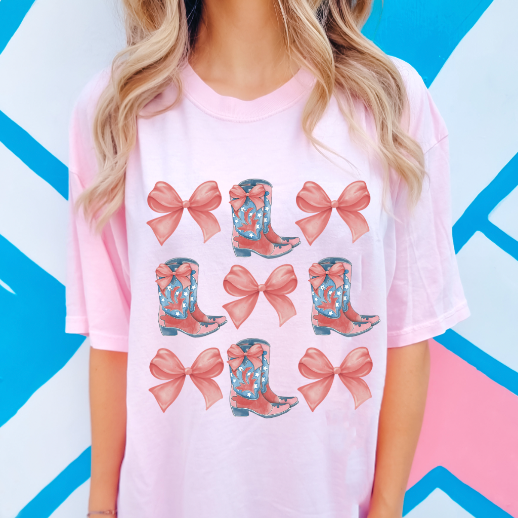 A women's graphic t-shirt with short sleeves, featuring Bow and Boot design. This soft, comfortable short sleeve tee from Comfort Colors is perfect for bachelorette parties. It is available in white with pink font or pink with white font, in sizes Small to 2XL.