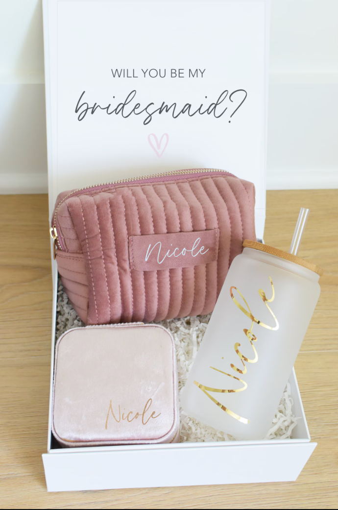 A Bridesmaid Proposal Box with a magnetic lid, personalized glass tumbler, jewelry box, and make-up bag.