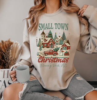 Person wearing a 'Small Town Christmas' sweatshirt with a festive design.
