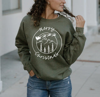 Person wearing a green sweatshirt with 'Merry Christmas' design outdoors.