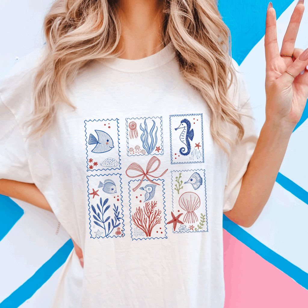 Infuse your wardrobe with seaside charm through the Coastal Vintage Stamp Comfort Colors Graphic Tee from Melody Faye. This tee showcases whimsical marine life illustrations in vintage-inspired stamp designs, offering a playful nod to coastal aesthetics. Crafted from soft, garment-dyed cotton, it provides a relaxed, oversized fit that's perfect for beach outings, summer adventures, or casual everyday wear. Designed and printed in the USA, this tee combines comfort with coastal flair.​