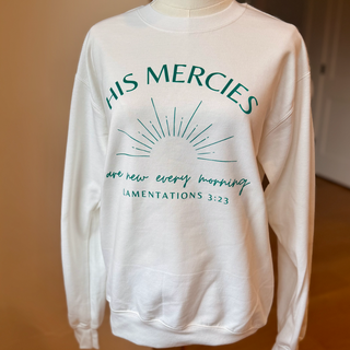 White sweatshirt with green text and design on a wooden surface
