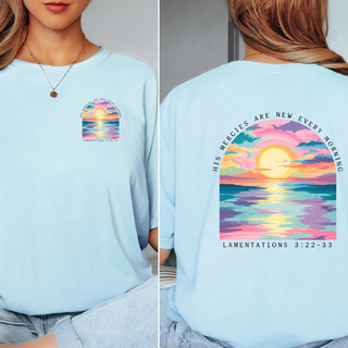 Light blue sweatshirt with sunset design on front and back, worn by a person.