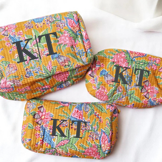 Three floral-patterned pouches with 'KT' initials on a white background
