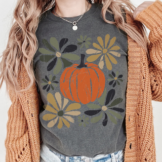 Person wearing a gray t-shirt with a pumpkin and floral design, paired with a brown cardigan.