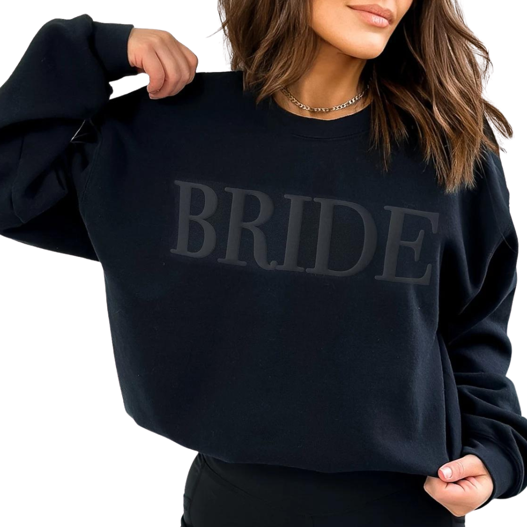 A women's crewneck sweatshirt with the word "Bride" elegantly embssed text on the front. This soft and comfortable black sweatshirt is perfect for the bride-to-be as she prepares for her big day. Available in unisex sizes Small to Extra Large, made from a preshrunk 50/50 cotton and polyester blend.