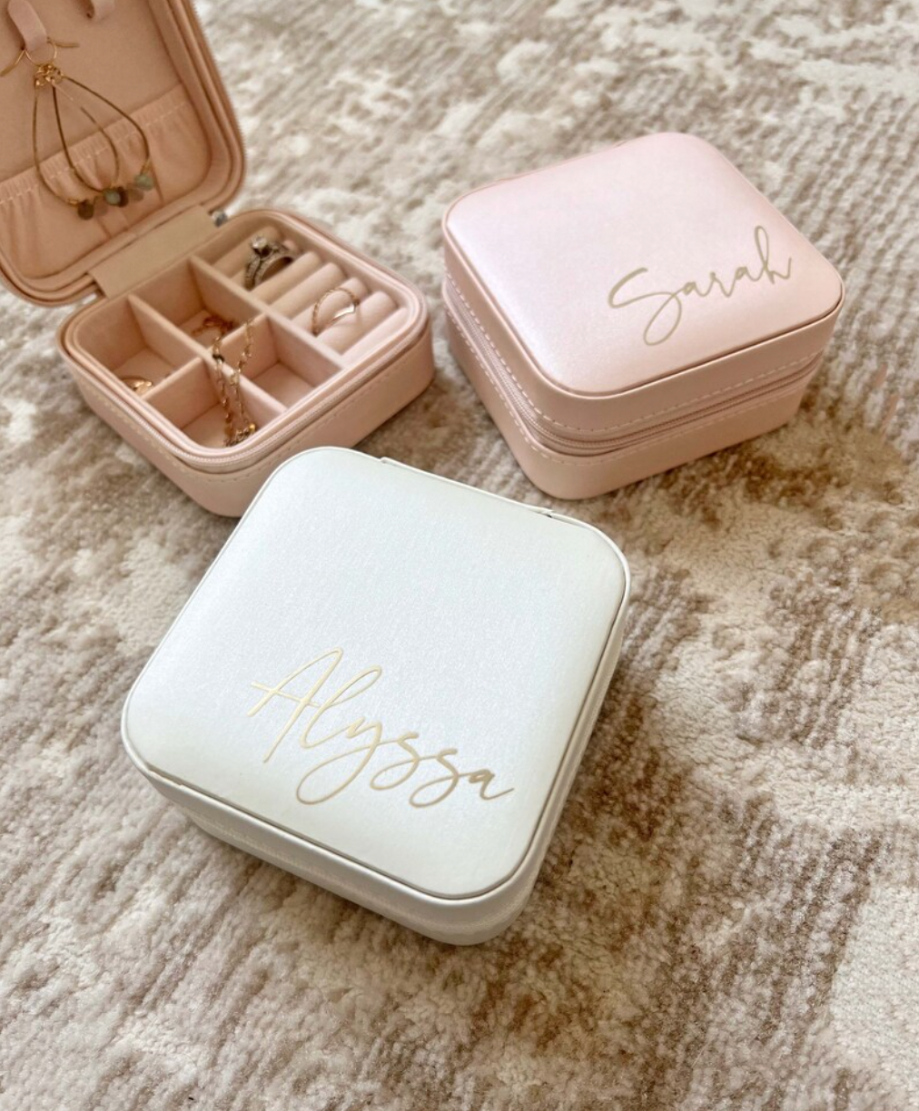 A personalized jewelry box designed for bridesmaids, available in three colors with options for three font colors. This travel-friendly box is stylish and practical, with compartments to hold jewelry securely. It makes an ideal gift for bridesmaids, perfect for storing jewelry while on the go, and can be personalized with names or monograms.