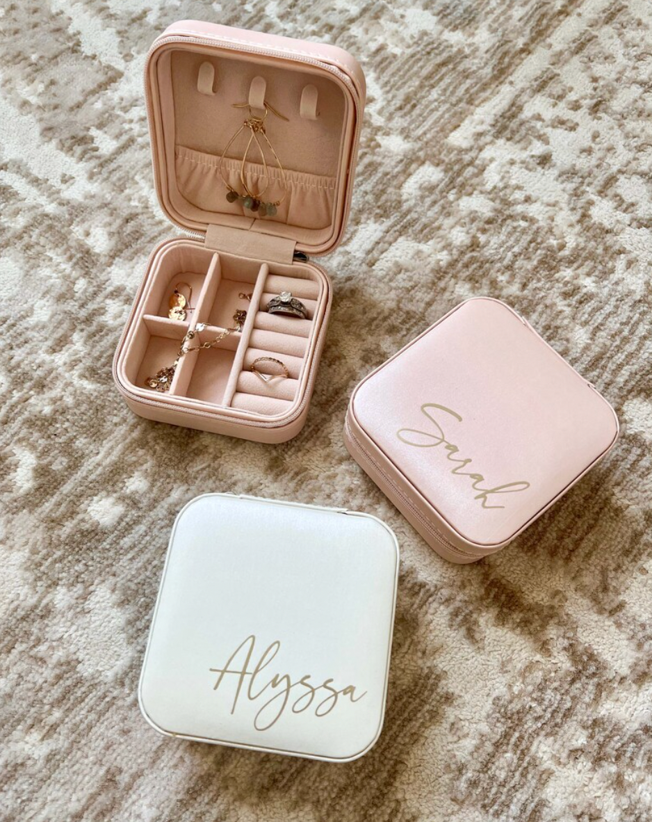 A personalized jewelry box designed for bridesmaids, available in three colors with options for three font colors. This travel-friendly box is stylish and practical, with compartments to hold jewelry securely. It makes an ideal gift for bridesmaids, perfect for storing jewelry while on the go, and can be personalized with names or monograms.