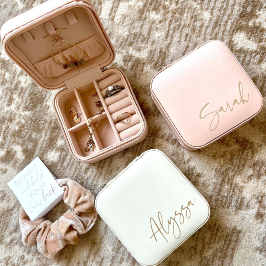 A personalized jewelry box designed for bridesmaids, available in three colors with options for three font colors. This travel-friendly box is stylish and practical, with compartments to hold jewelry securely. It makes an ideal gift for bridesmaids, perfect for storing jewelry while on the go, and can be personalized with names or monograms.